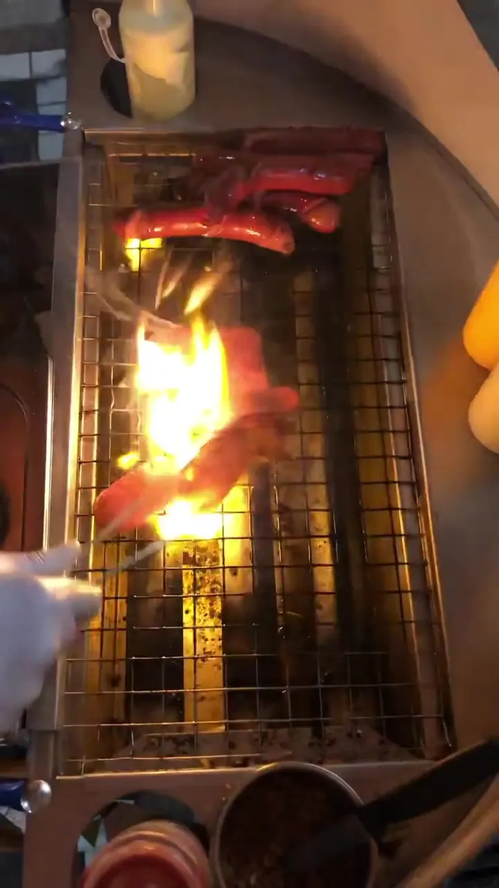 Sucuk und Rindswurst über offener Flamme auf dem Grill